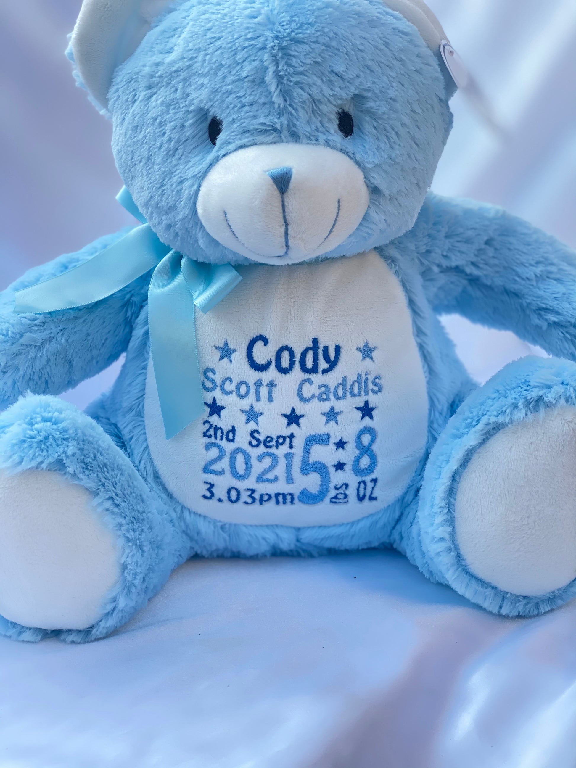 Personalised pastel blue teddy bear with embroidered name, featuring zipped bottom and removable inner pod for keepsakes or pyjamas