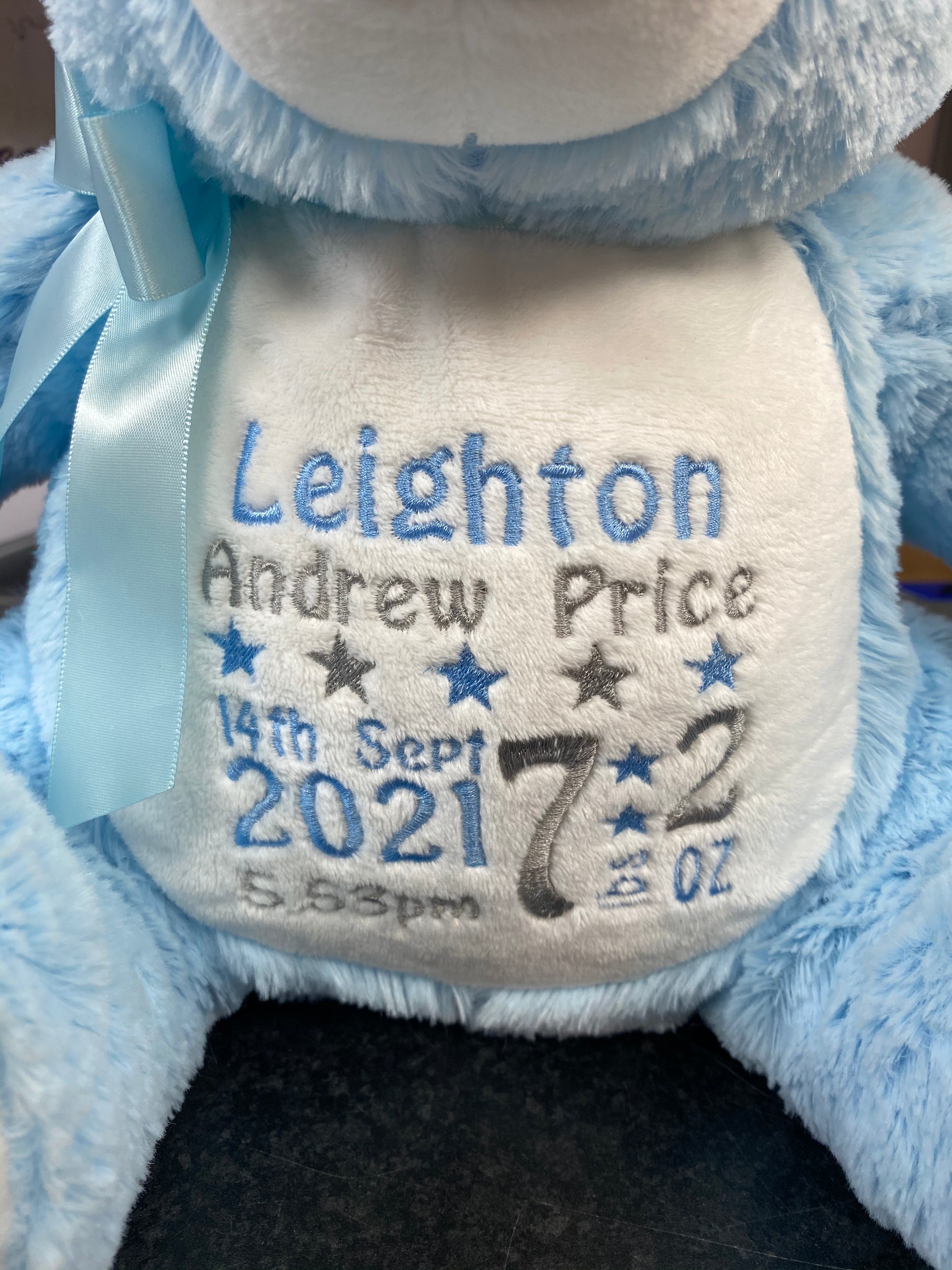 Personalised pastel blue teddy bear with embroidered name, featuring zipped bottom and removable inner pod for keepsakes or pyjamas